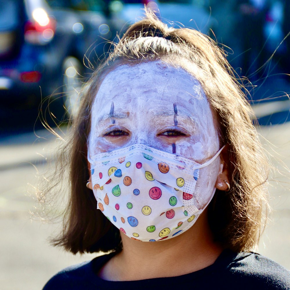 Ragazza con la pittura facciale che indossa la camicia nera