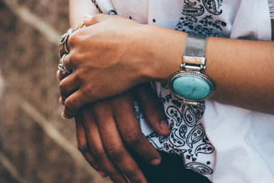 Elegant hand adorned with fine rings and a subtle wrist piercing.