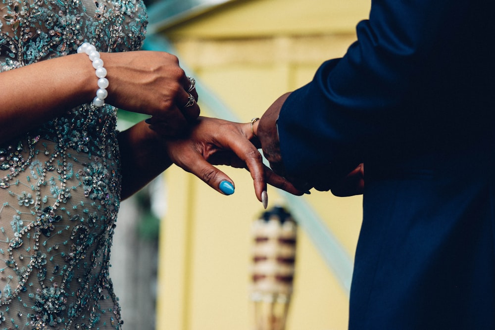 woman in black and white floral dress holding mans hand