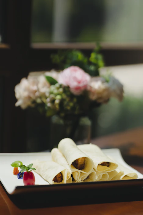 Elegant plating of Marbella Sombra’s premium tortillas paired with a glass of fine wine in a stylish Riyadh setting.