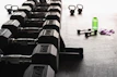 Fitness equipment like dumbbells and water bottles presented on clean white background