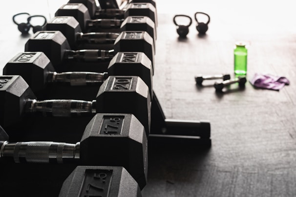 A tidy workout corner with dumbbells, resistance bands, and a water bottle ready for a quick session.