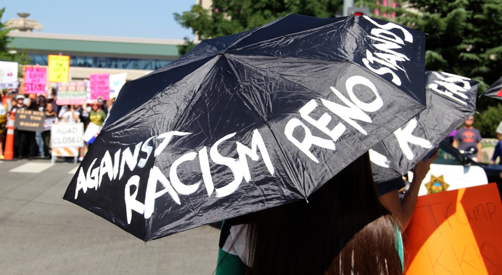 woman in black and white t-shirt holding black umbrella