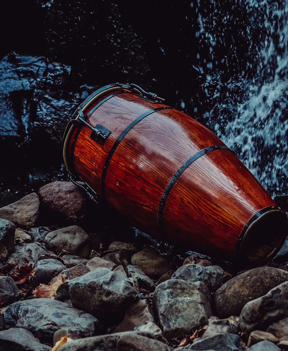 brown wooden barrel on rocky shore