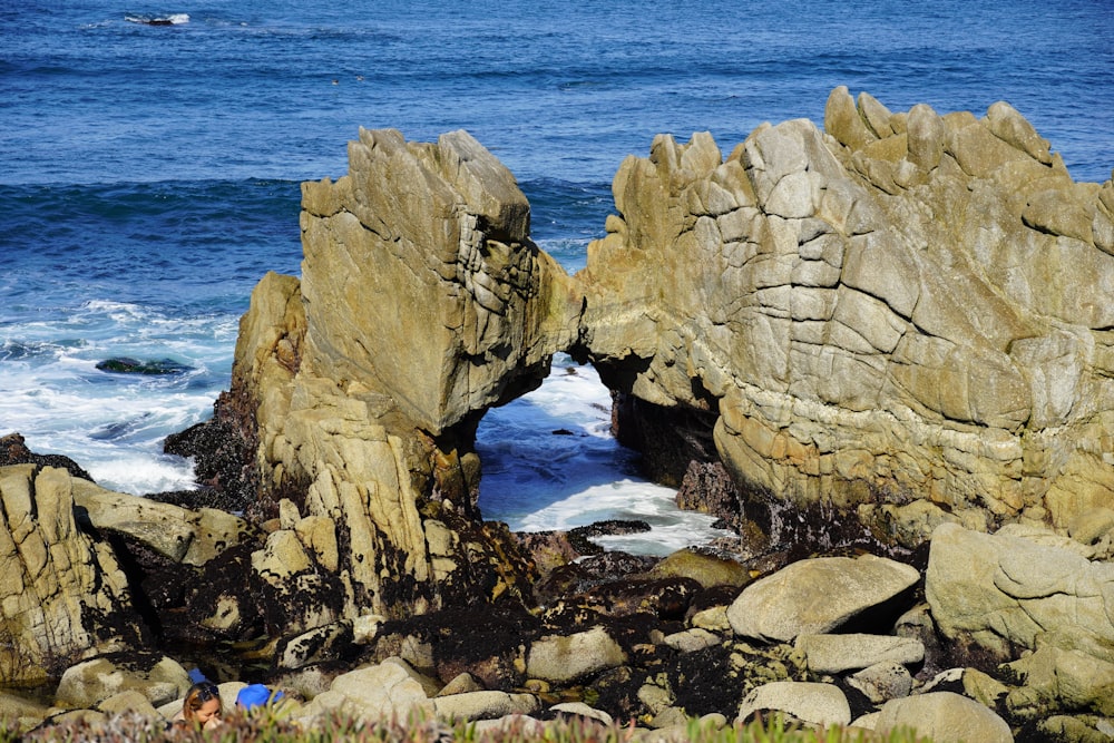 formazione rocciosa marrone sullo specchio d'acqua durante il giorno