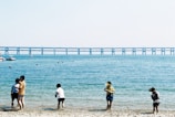Children smiling and playing by the sea with dolphins nearby