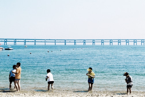 Children smiling and playing by the sea with dolphins nearby