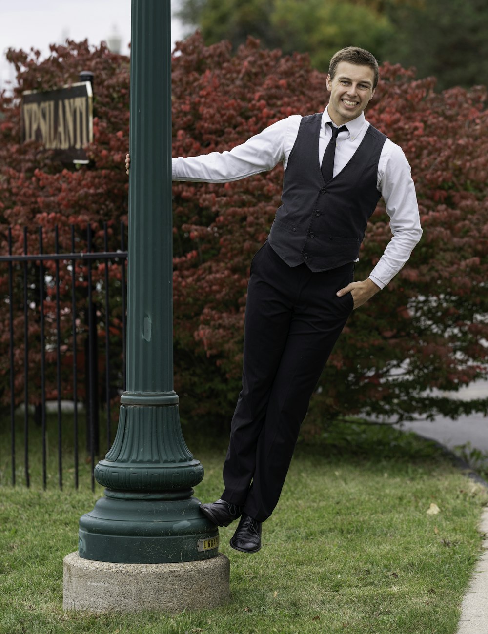 man in black suit standing on green grass field