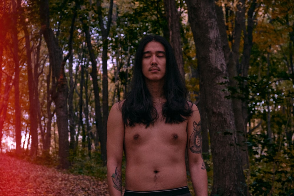 topless woman standing near trees during daytime