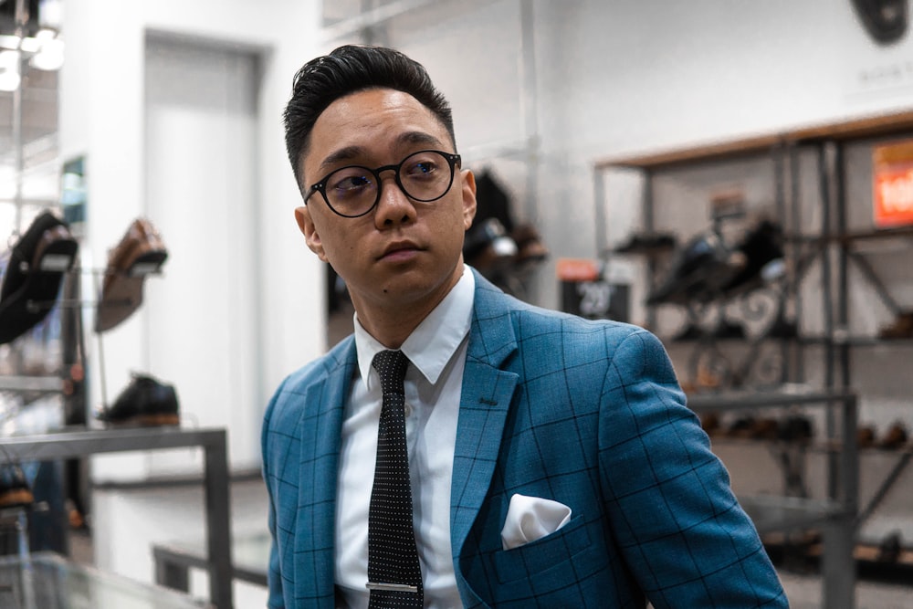 Hombre con traje azul con gafas de montura negra