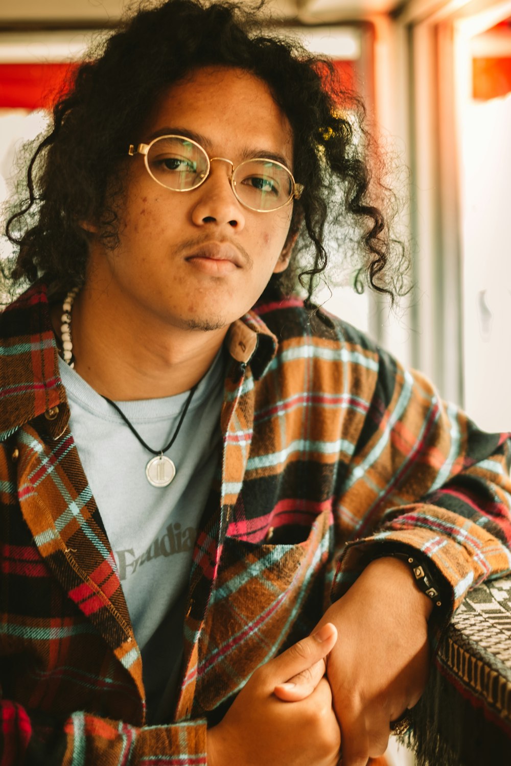 woman in red white and black plaid button up shirt wearing black framed eyeglasses