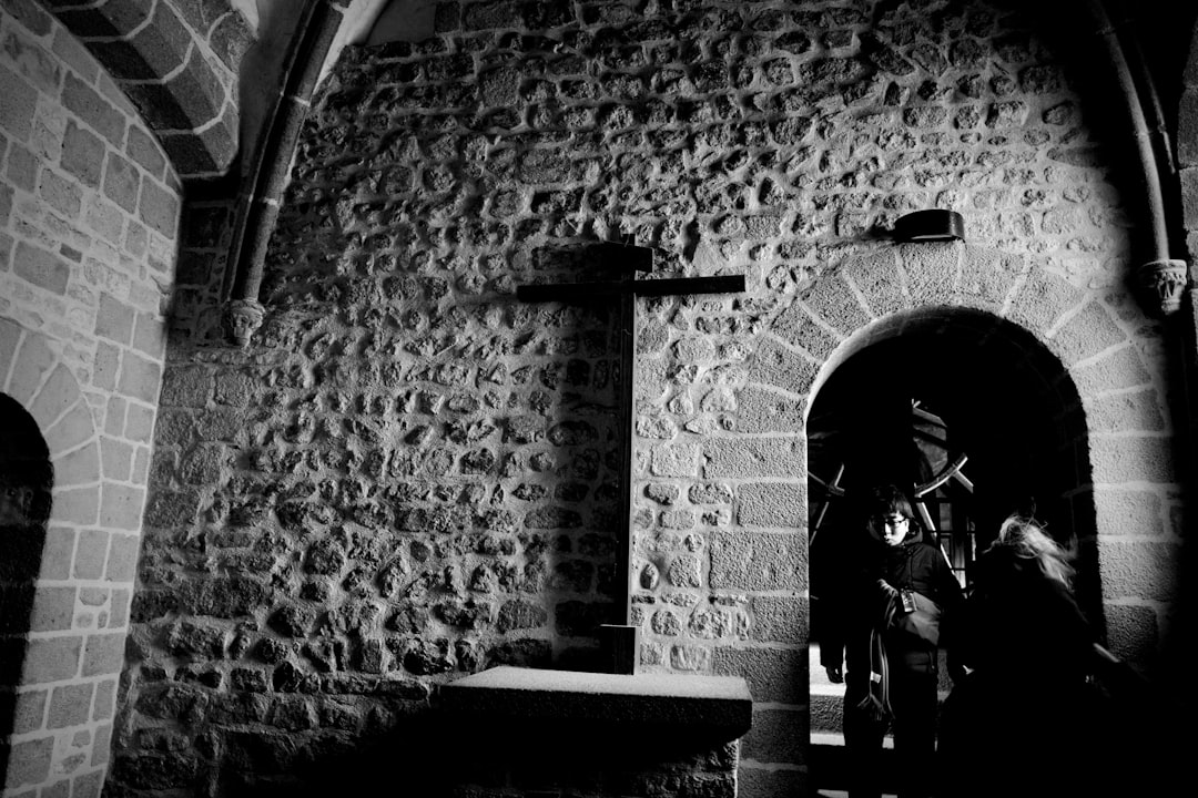 man in black jacket standing near wall