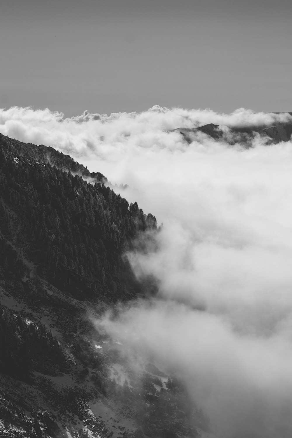 grayscale photo of mountain under cloudy sky