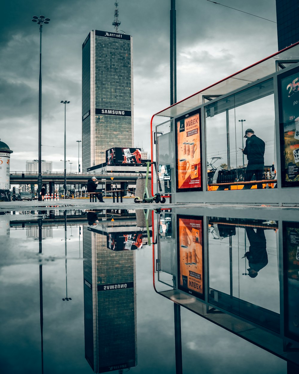 man in black jacket standing near glass window building during daytime