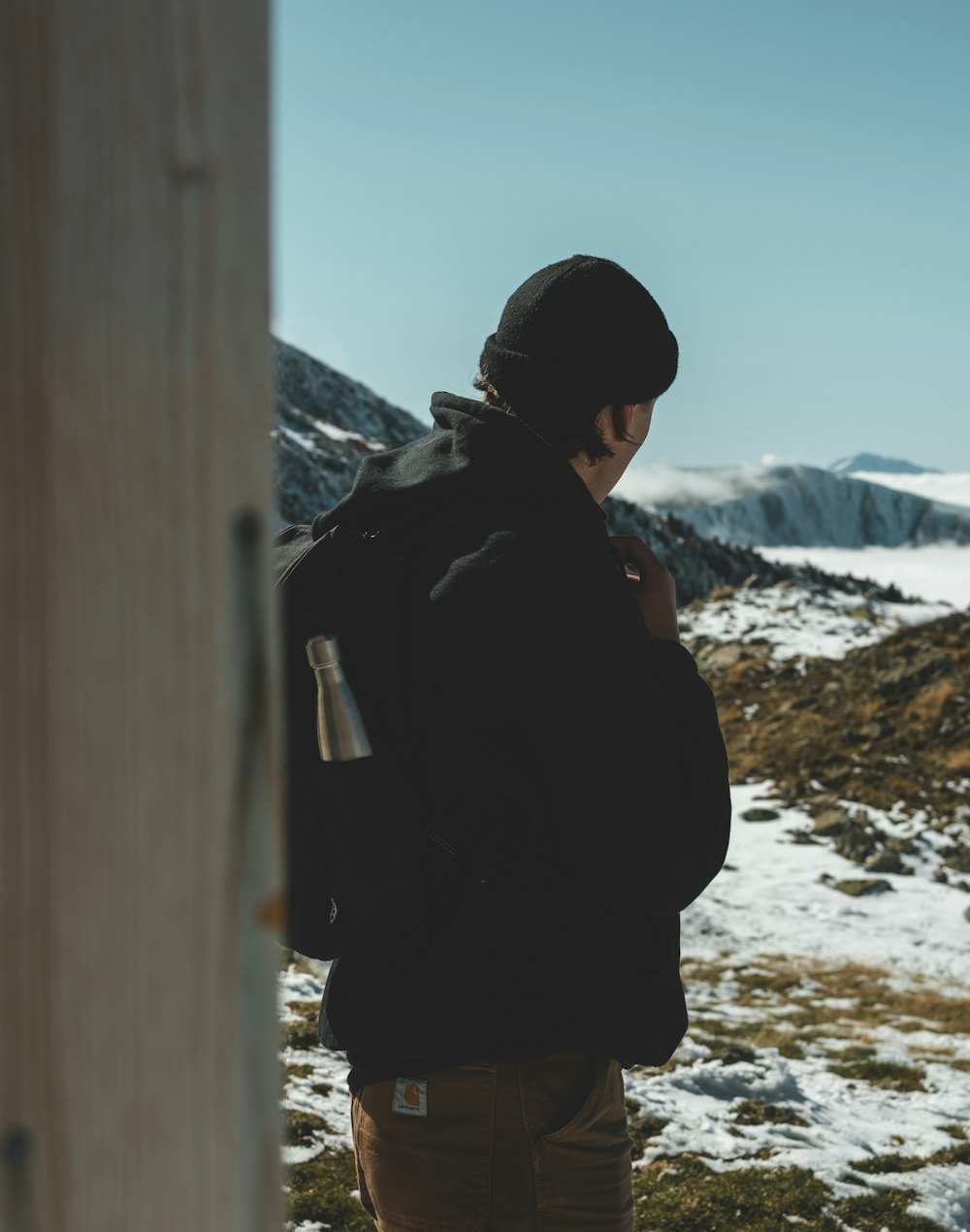 man in black jacket standing on snow covered ground during daytime