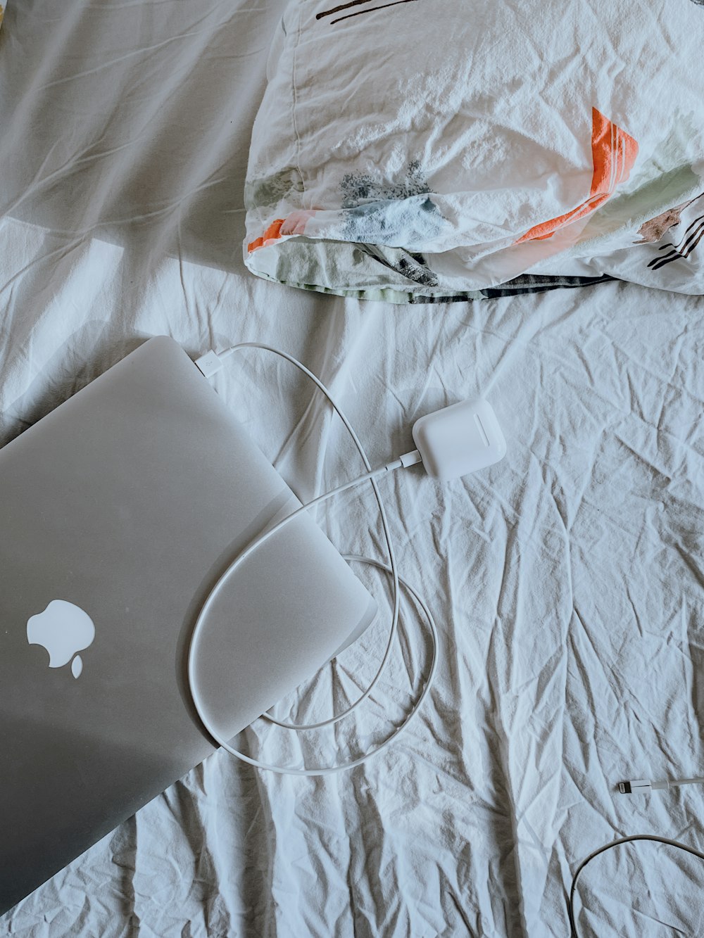 silver macbook on white textile