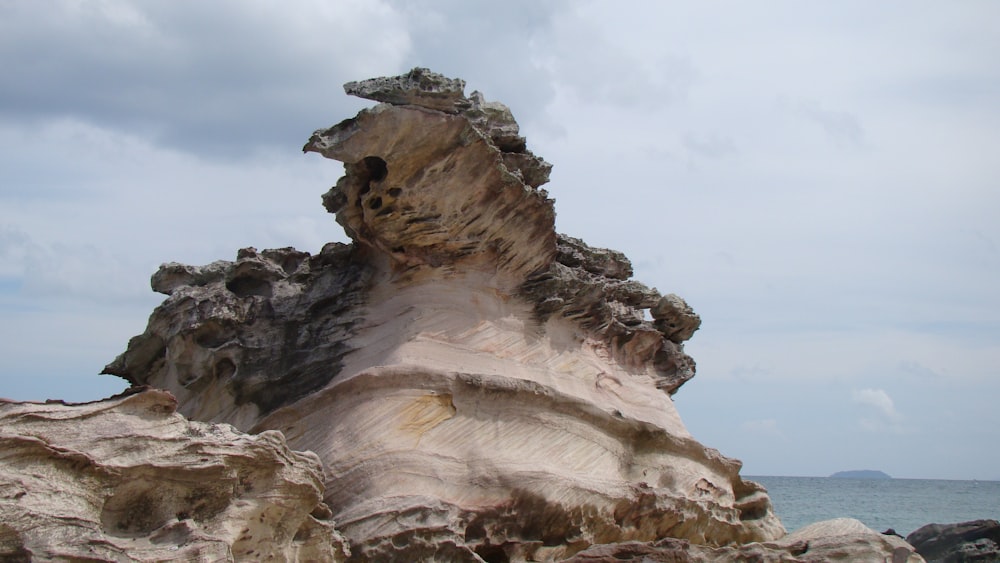 brown and gray rock formation under white clouds during daytime