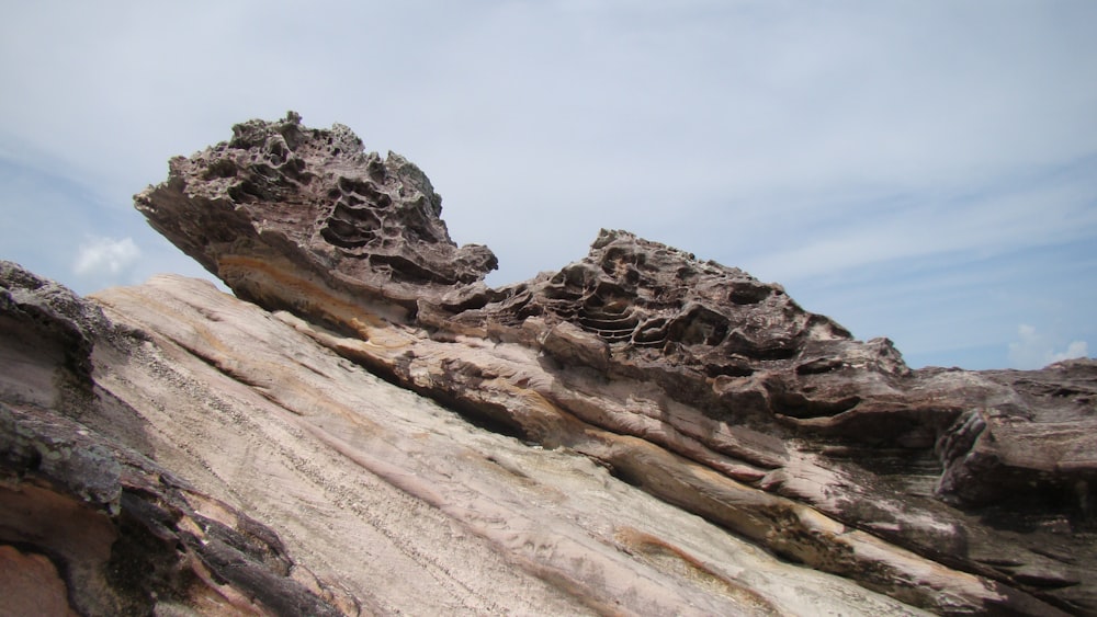 brown rock formation under white clouds during daytime