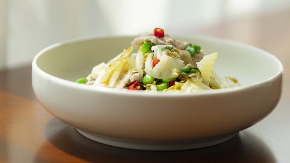 white ceramic bowl with white cream and green vegetable