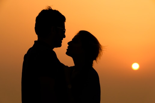 silhouette of woman wearing sunglasses during sunset