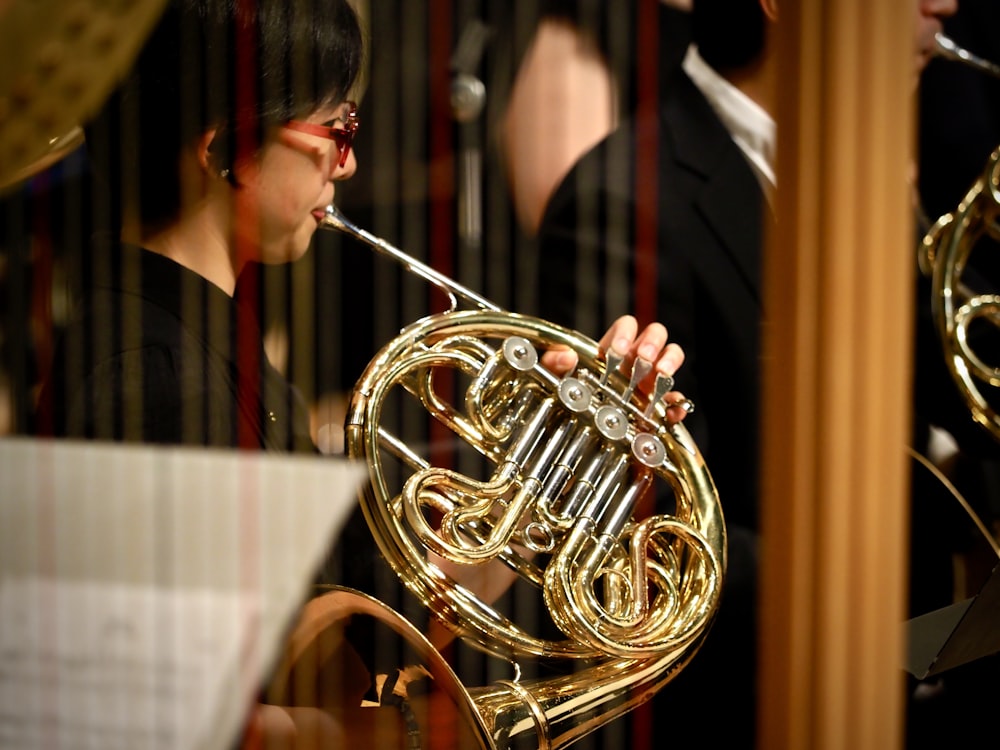 woman in red shirt playing brass trumpet