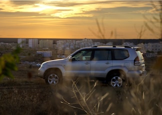 gray suv on brown field during daytime