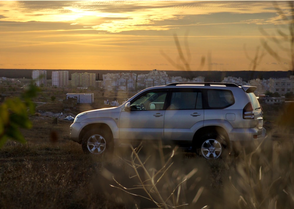 gray suv on brown field during daytime