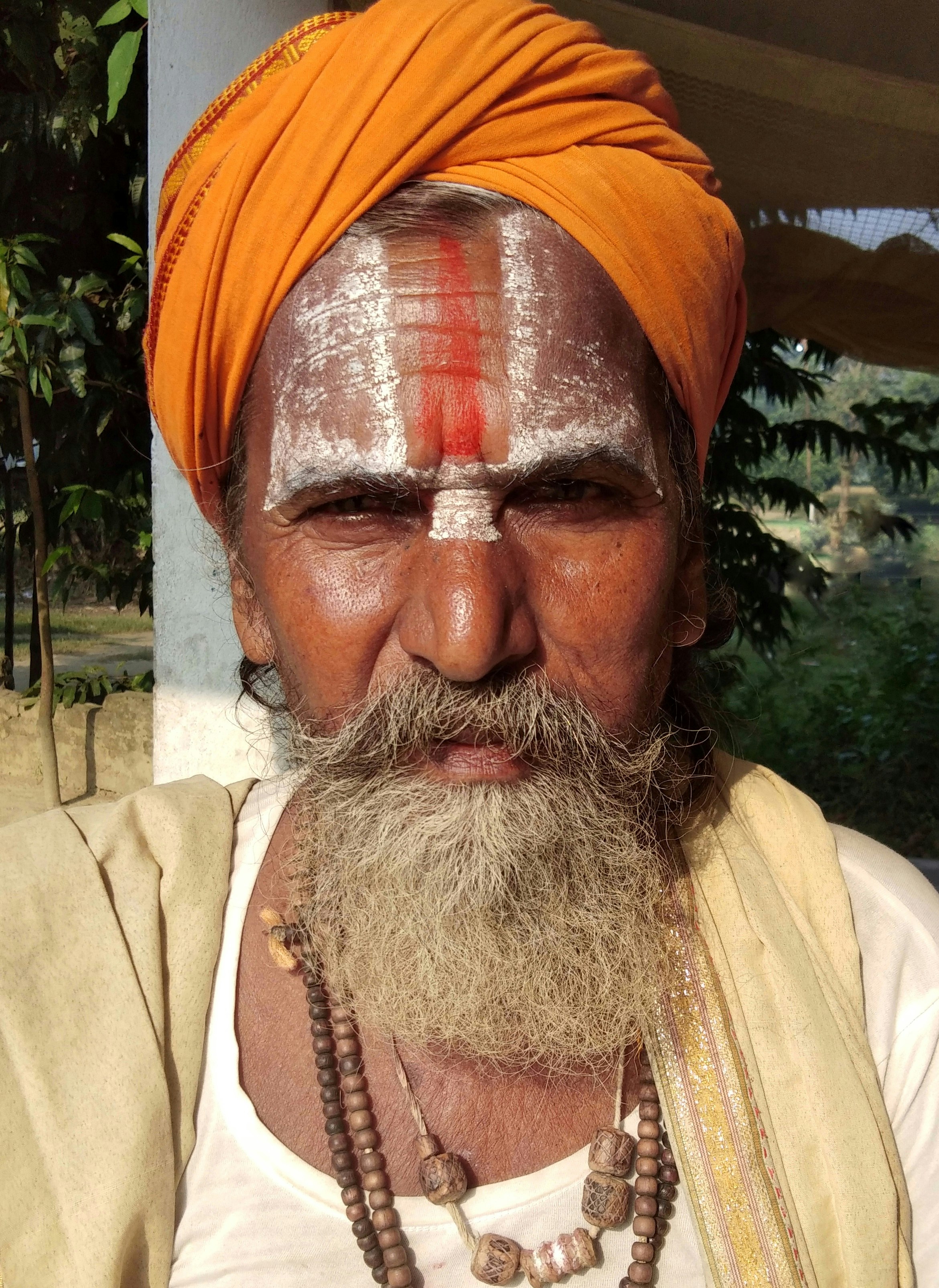 man in orange turban and white shirt