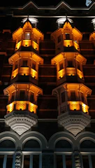 Nighttime façade lighting render highlighting architectural features with gold glow.