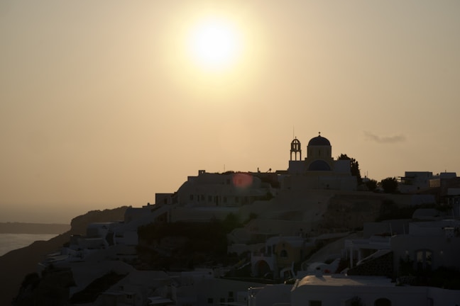 A serene sunset over Santorini’s whitewashed buildings and blue domes.