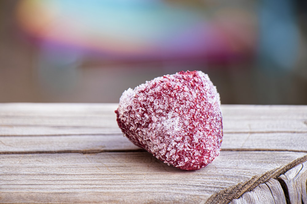 pink and white heart shaped stone on brown wooden table