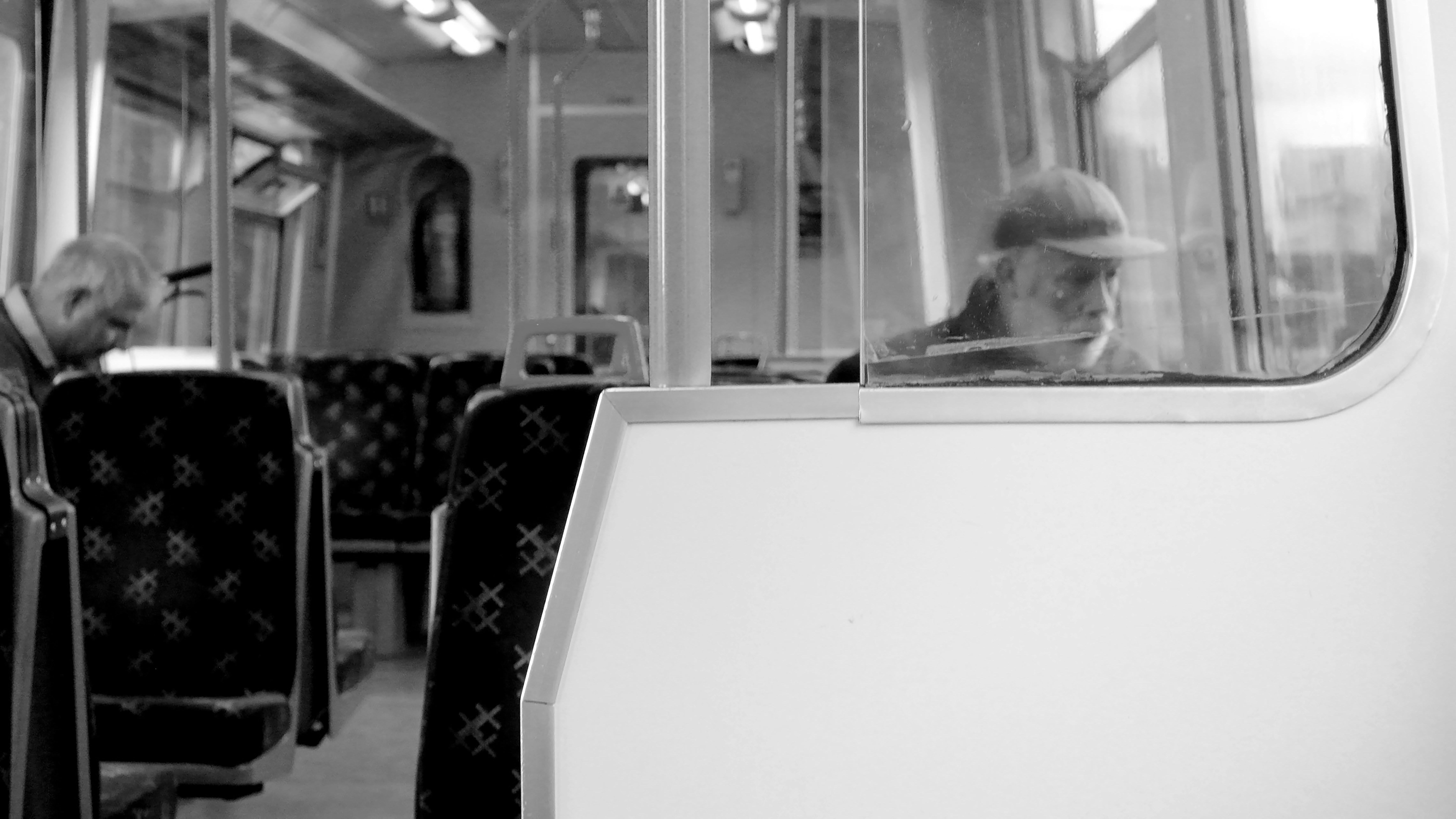 grayscale photo of man sitting on chair