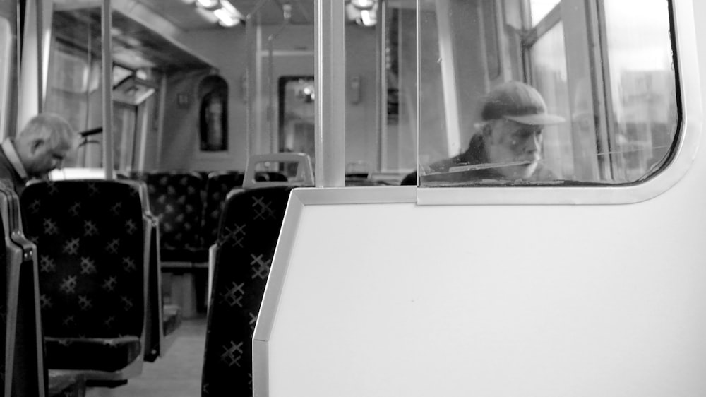 grayscale photo of man sitting on chair