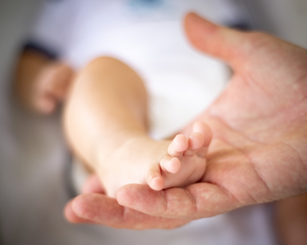 person holding babys feet