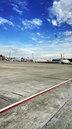 Aerial view of an airport runway with fuel trucks lined up ready for delivery.