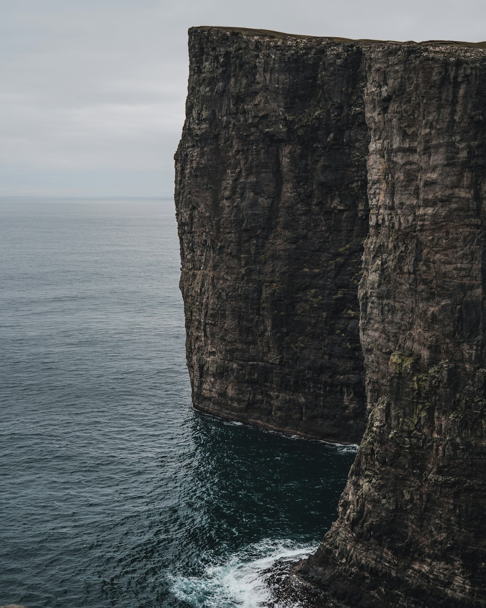 brown rock formation beside body of water during daytime