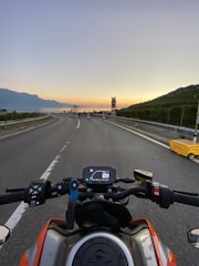 A sunset view over a European countryside road with a motorbike cruising along.