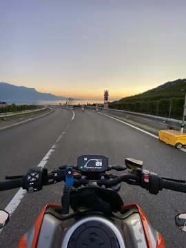 A sunset view over a European countryside road with a motorbike cruising along.