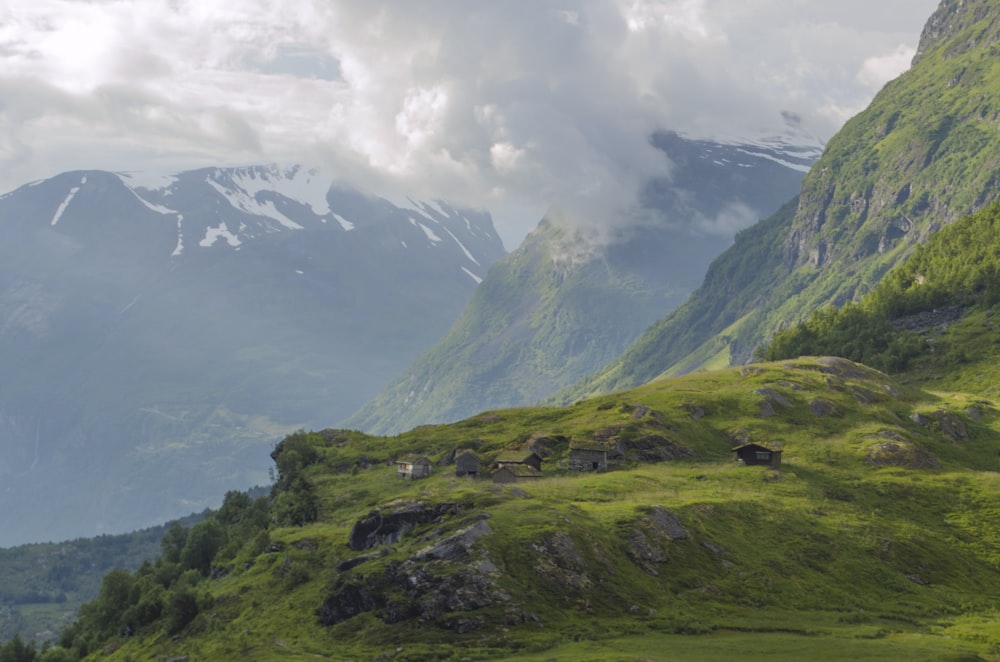 green grass covered mountain under white clouds during daytime