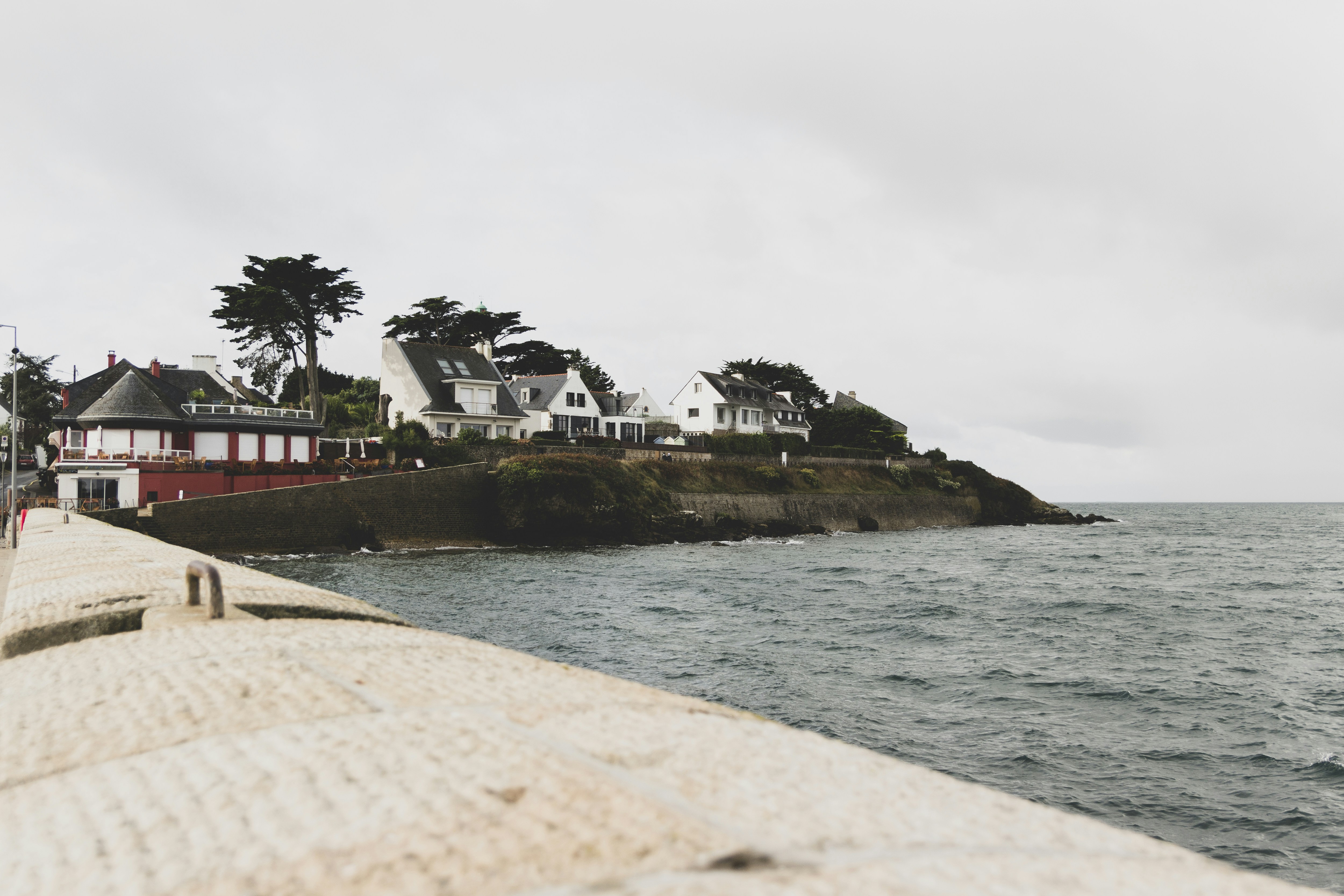 white and brown house near body of water during daytime