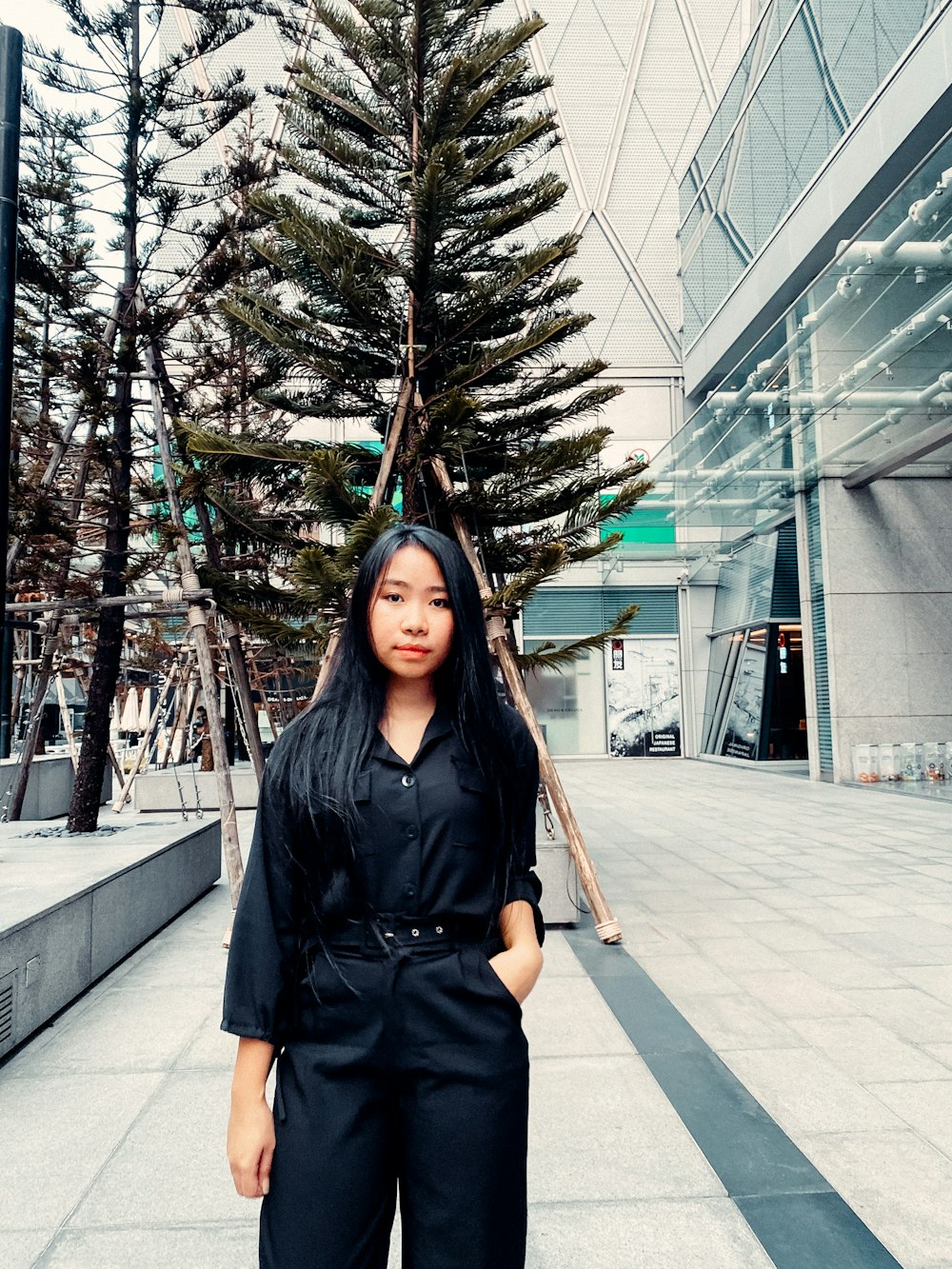 woman in black button up shirt standing on sidewalk during daytime