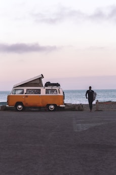 man in black jacket standing on beach during daytime