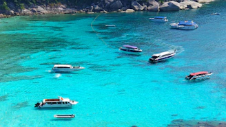 Crystal-clear turquoise waves sparkling as the boat glides past rocky cliffs and hidden coves.
