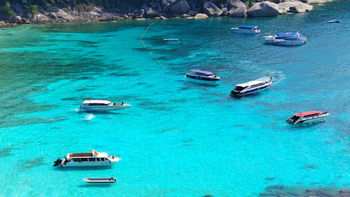 Crystal-clear turquoise waves sparkling as the boat glides past rocky cliffs and hidden coves.