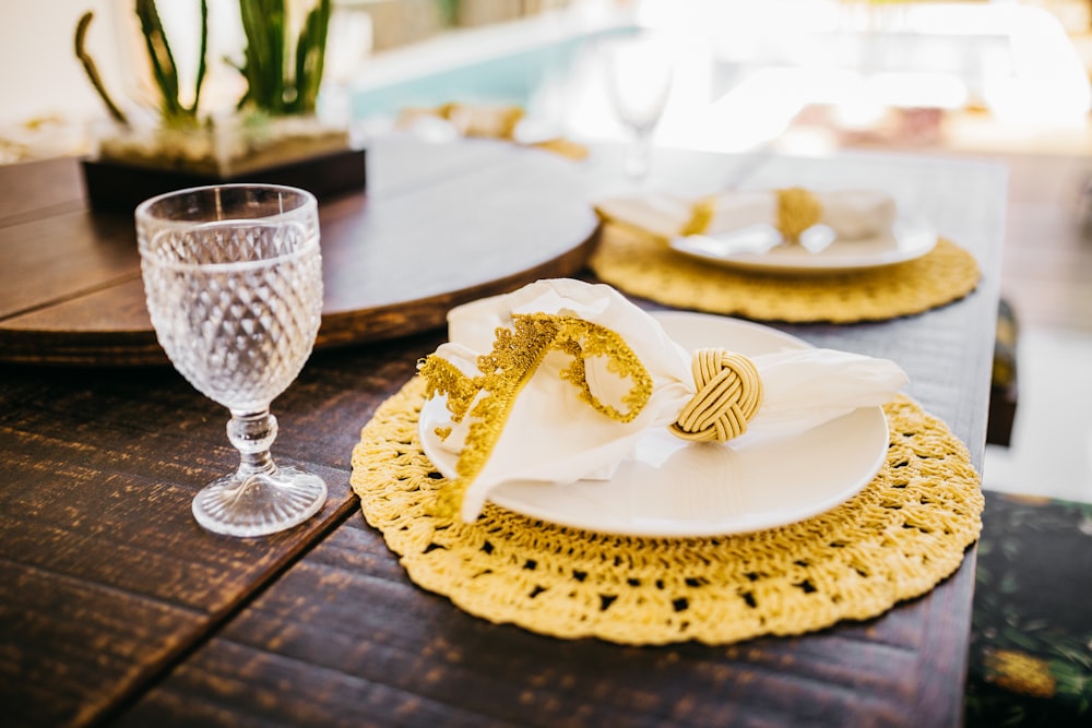 茶色の木製のテーブルに白と金の丸いプレート