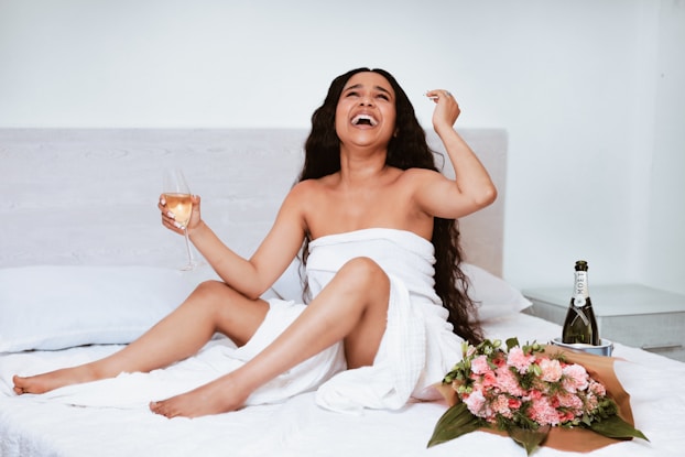 woman in white tube dress holding clear wine glass