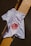 A white t-shirt is laid over a tiled surface that consists of black and yellow tiles. The t-shirt has a graphic design featuring a red circular image resembling a celestial body, along with some text and arrows.