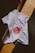 A white t-shirt is laid over a tiled surface that consists of black and yellow tiles. The t-shirt has a graphic design featuring a red circular image resembling a celestial body, along with some text and arrows.