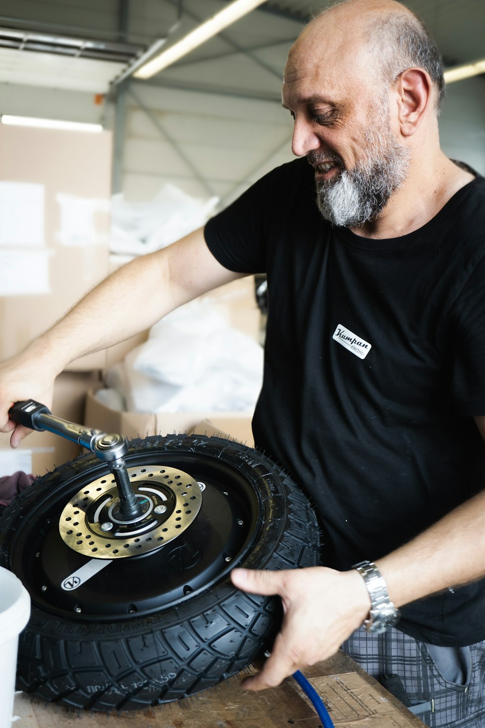 uomo in t-shirt girocollo nera che tiene la ruota nera