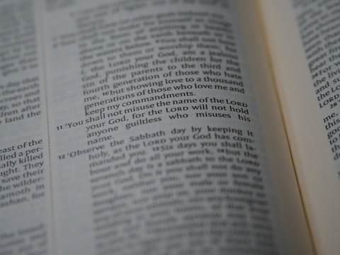 A close-up of an open Bible showing a passage with numbered verses. The focus is on verse 11, which discusses the use of the Lord's name. The text appears in two columns with a slight tilt.